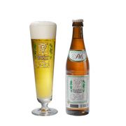 A bottle of Augustiner Pils beer next to a tall stemmed glass filled with the golden beer and frothy head, on a plain white background.