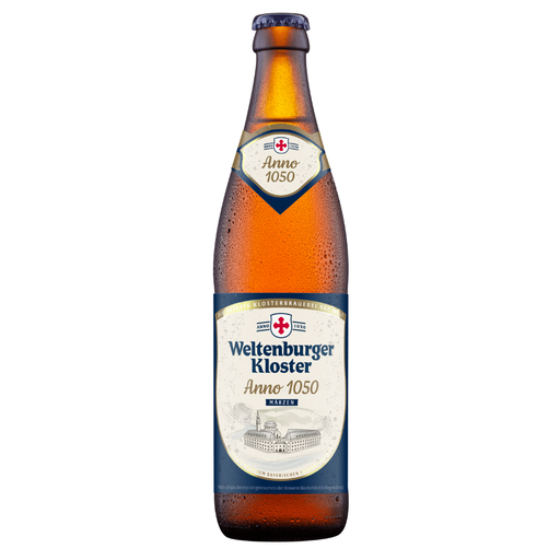 A single bottle of Weltenburger Kloster Anno 1050 beer on a plain white background. The amber glass bottle is covered in condensation droplets and features a cream and navy blue label with a red cross logo.