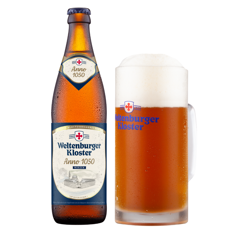 A bottle of Weltenburger Kloster Anno 1050 beer next to a frothy glass mug of the same beer on a white background.